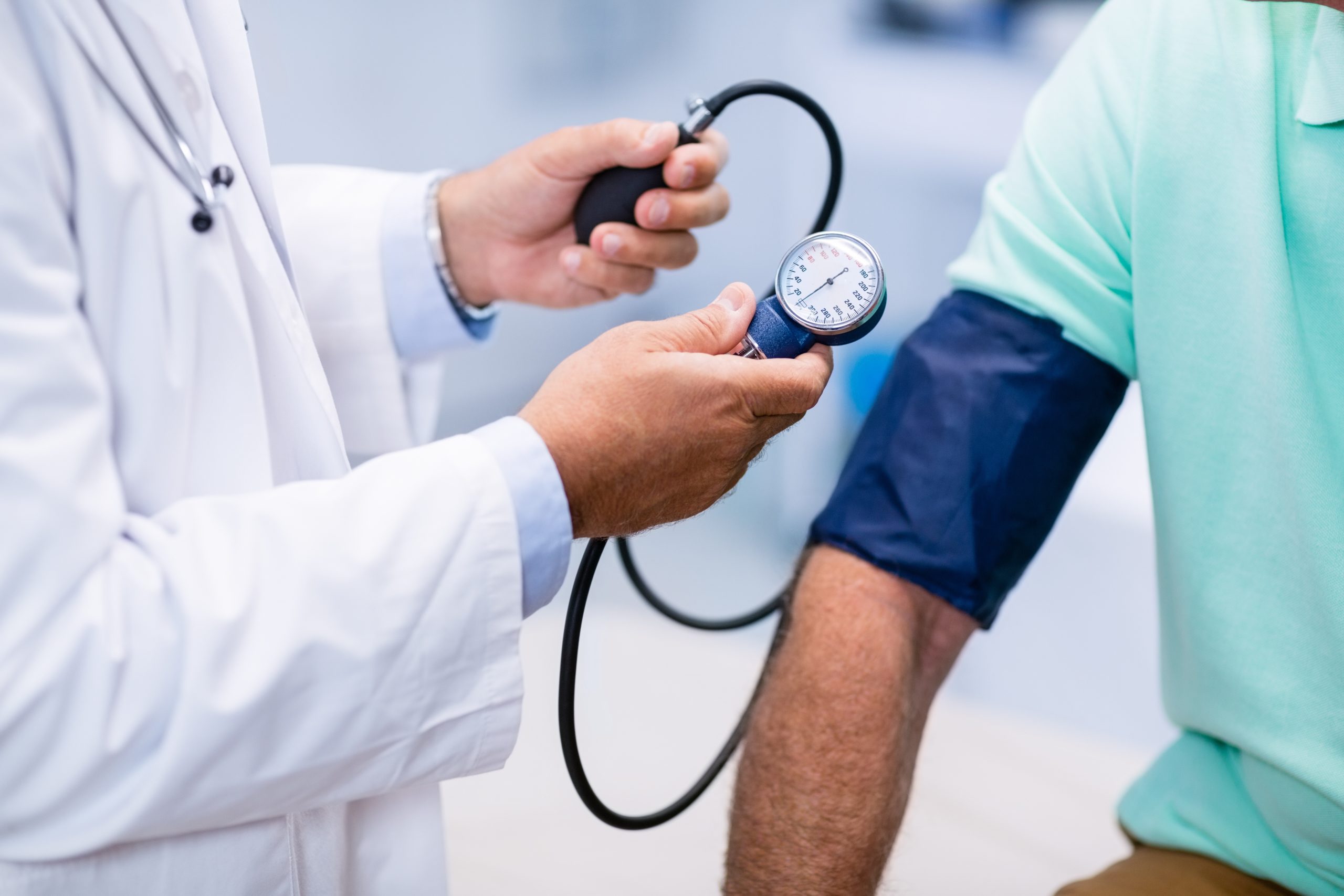 Mid section of doctor checking blood pressure of a patient