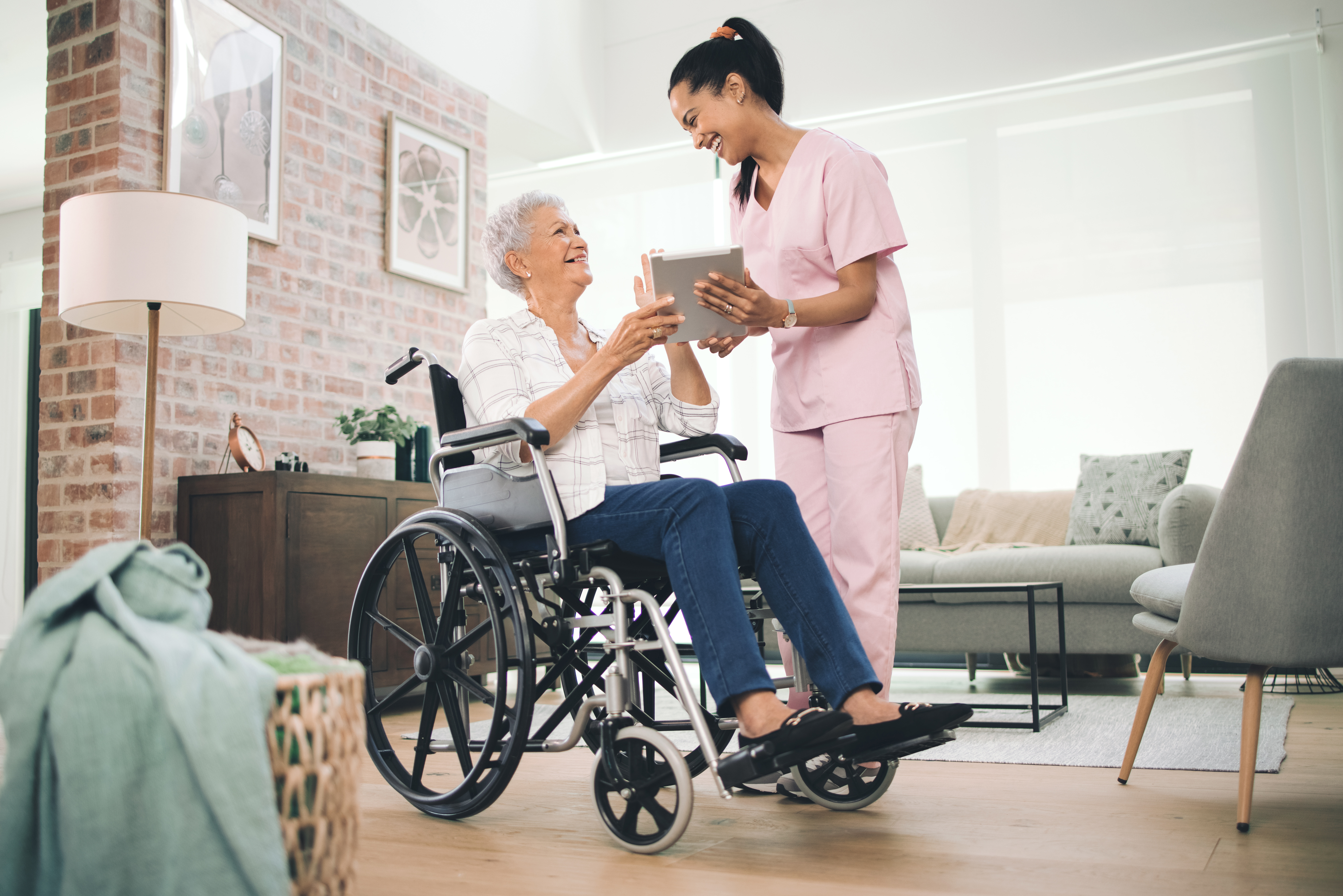 Ive captured all your big moments. Shot of a young nurse sharing information from her digital tablet with an older woman in a wheelchair.